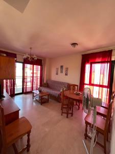 ein Wohnzimmer mit einem Sofa und einem Tisch in der Unterkunft BAHIA alquiler solo para familias in Playa de Gandia