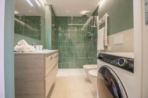 La salle de bains est pourvue d'une douche et d'un lave-linge. dans l'établissement Portisco Bouganville Seaside Charm Flat W/ Veranda, à Marina di Portisco