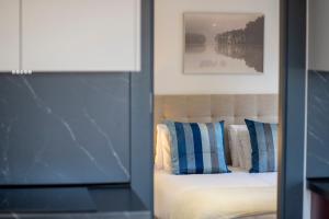 een slaapkamer met een bed met blauwe en witte kussens bij Apartamentos MLC Ciudad de Linares in Linares