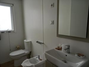 uma casa de banho com um WC, um lavatório e um espelho. em Bahia Blanca em Gaeta