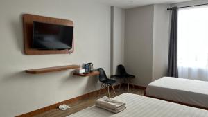 a room with two beds and a tv on the wall at RedDoorz Premium at Jalan Diponegoro Lampung in Bandar Lampung