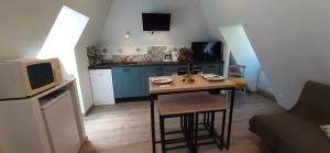 una pequeña cocina con una pequeña mesa en una habitación en Appartement Habas Estaing Hautes Pyrénées Val d'Azun, en Estaing