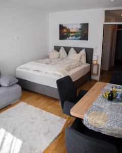 a bedroom with a large bed and a table at Eva Apartments - Bergisel in Innsbruck