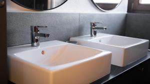 a bathroom with a white sink and two faucets at Eva Apartments - Bergisel in Innsbruck