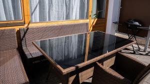 uma mesa de vidro com duas cadeiras em frente a uma porta em Eva Apartments - Bergisel em Innsbruck