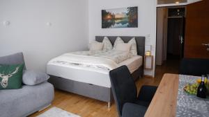 a bedroom with a bed and a couch and a table at Eva Apartments - Bergisel in Innsbruck
