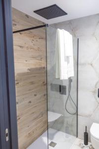 een douche met een glazen deur in de badkamer bij Apartamentos MLC Ciudad de Linares in Linares