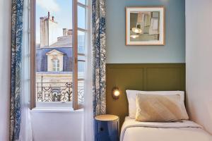 a bedroom with a bed and a window at Hôtel Bordeaux Clémenceau by Happyculture in Bordeaux