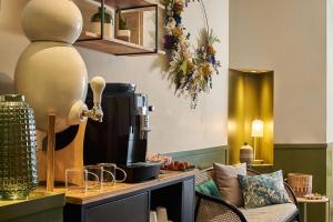 a room with a coffee maker on a counter with a chair at Hôtel Bordeaux Clémenceau by Happyculture in Bordeaux