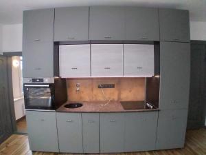 a kitchen with white cabinets and a counter top at Apartament Panaceum- Panaceum Apartment in Gdańsk