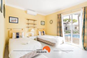 two beds in a room with a window at #214 Vivenda 3 Quartos by Home Holidays in Branqueira +53 photos