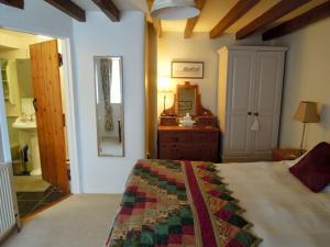 a bedroom with a bed and a dresser and a mirror at The Granary in St Austell