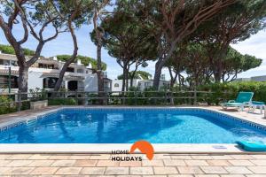 a swimming pool in front of a house with trees at #214 Vivenda 3 Quartos by Home Holidays in Branqueira