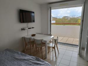 a bedroom with a table and chairs and a television at Disney Horizon Parc Studio 5 personnes PK privé gratuit balcon lit bébé in Montévrain