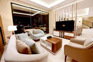 uma sala de estar com sofás e uma televisão de ecrã plano em أبهى سكن للشقق المخدومة em Abha