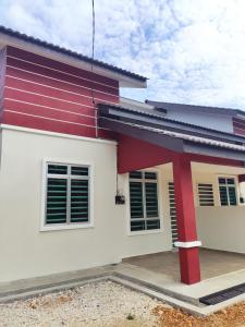 a house with a red and white facade at ABHAR Inap Desa in Alor Setar