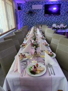 a long table with plates of food on it at Penzion Carlos in Podlužany