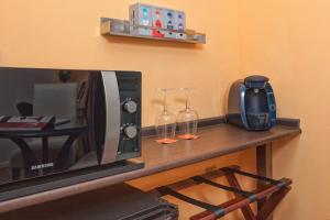 a counter with a microwave and two wine glasses at Boutique Hotel Pueblo in Benalmádena