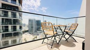 杜拜的住宿－OYO 1290 Home Fully Furnished 1bed Apartment @JVC，大楼阳台上的两把椅子和一张桌子