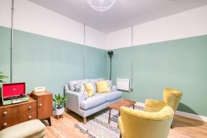 a living room with a couch and two chairs at PH Hostel Birmingham in Birmingham