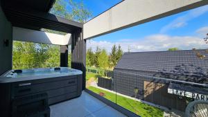 a bathroom with a tub and a large window at Lake Park in Zator