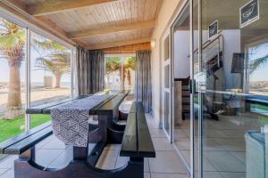 ein Esszimmer mit einem Tisch und Strandblick in der Unterkunft Waterfront Cottage B3 in Swakopmund