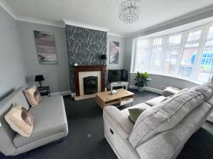 a living room with a couch and a fireplace at M1 Link 2 bed house up to 4 people, free parking,wifi,M1,transport links,garden in Sutton in Ashfield