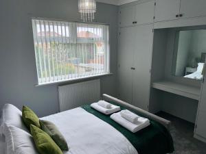 1 dormitorio con 1 cama con 2 toallas en M1 Link 2 bed house up to 4 people, free parking,wifi,M1,transport links,garden, en Sutton-in-Ashfield