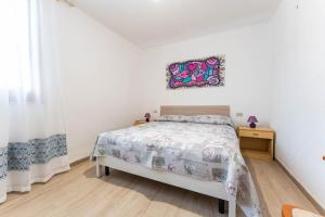 een slaapkamer met een bed en een foto aan de muur bij Elena’s Maison in Solanas