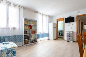 een woonkamer met een koelkast en een keuken bij Elena’s Maison in Solanas