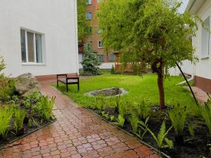 Romny的住宿－Орхідея，院子中一个带长凳和一棵树的公园