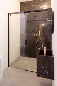 La salle de bains est pourvue d'une douche avec une porte en verre. dans l'établissement Destiny home 5 bardolino, à Bardolino