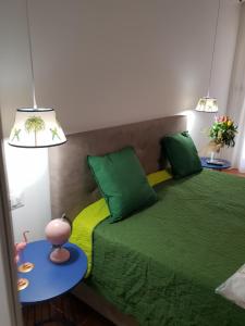 a bedroom with a green bed with two tables at Signora Irma in Margherita di Savoia