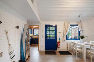 a dining room with a blue door and a table at Ferienhaus 'am Seeufer' in Sietow