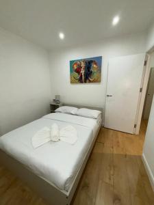 um quarto com uma cama branca e almofadas brancas em Sleep 4 In battersea Central 5 mins to Power Station BS2 em Londres