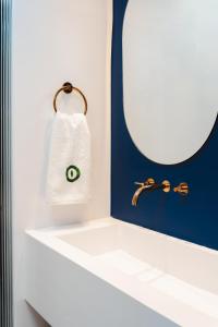 een badkamer met een witte wastafel en een spiegel bij Croco Mykonos in Tourlos