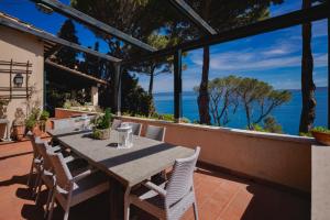 a table and chairs on a patio with a view of the ocean at [porto s. stefano] place like heaven + parcheggio in Porto Santo Stefano