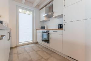 cocina con electrodomésticos blancos y ventana grande en Ida - Nordhorn, en Nordhorn