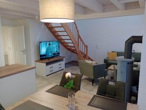 a living room with a television and a staircase at Ida - Nordhorn in Nordhorn