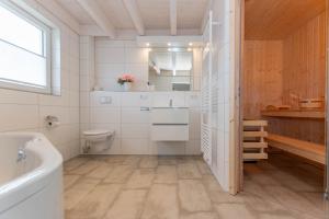 a bathroom with a tub and a toilet and a sink at Ida - Nordhorn in Nordhorn