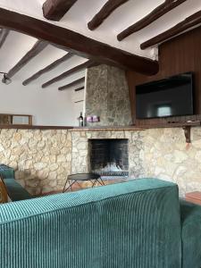 a living room with a couch and a stone fireplace at Casa Rural Cal Vellet del Priorat in La Vilella Baixa