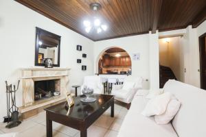 a living room with a white couch and a fireplace at Antzela's Town House Corfu in Alepou