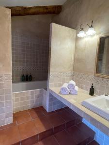ein Badezimmer mit einer Badewanne, einem Waschbecken und Handtüchern in der Unterkunft Casa Rural Cal Vellet del Priorat in La Vilella Baixa