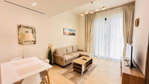ein Wohnzimmer mit einem Sofa und einem Tisch in der Unterkunft OYO 1289 Home Premium 1Bed Apartment At JVC in Dubai