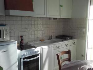 a kitchen with white appliances and white cabinets at Charmante maison avec parc arboré près du Zoo de Beauval - FR-1-491-335 in Meusnes
