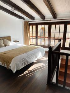 ein Schlafzimmer mit einem großen Bett und einigen Fenstern in der Unterkunft Casa Rural Cal Vellet del Priorat in La Vilella Baixa