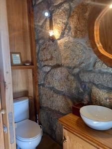 a stone bathroom with a toilet and a sink at Horizontes Serranos in Tondela