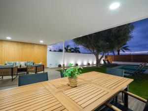 a dining room with a wooden table and a patio at Pasito Blanco Villas in Pasito Blanco