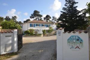 ein Haus mit einem Tor vor einem Haus in der Unterkunft Villa des 4 saisons in Saint-Trojan-les-Bains