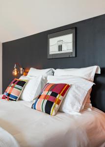 a bedroom with a white bed with colorful pillows at Maison d'Hôtes "Les Bulles Dorées" in Rilly-la-Montagne